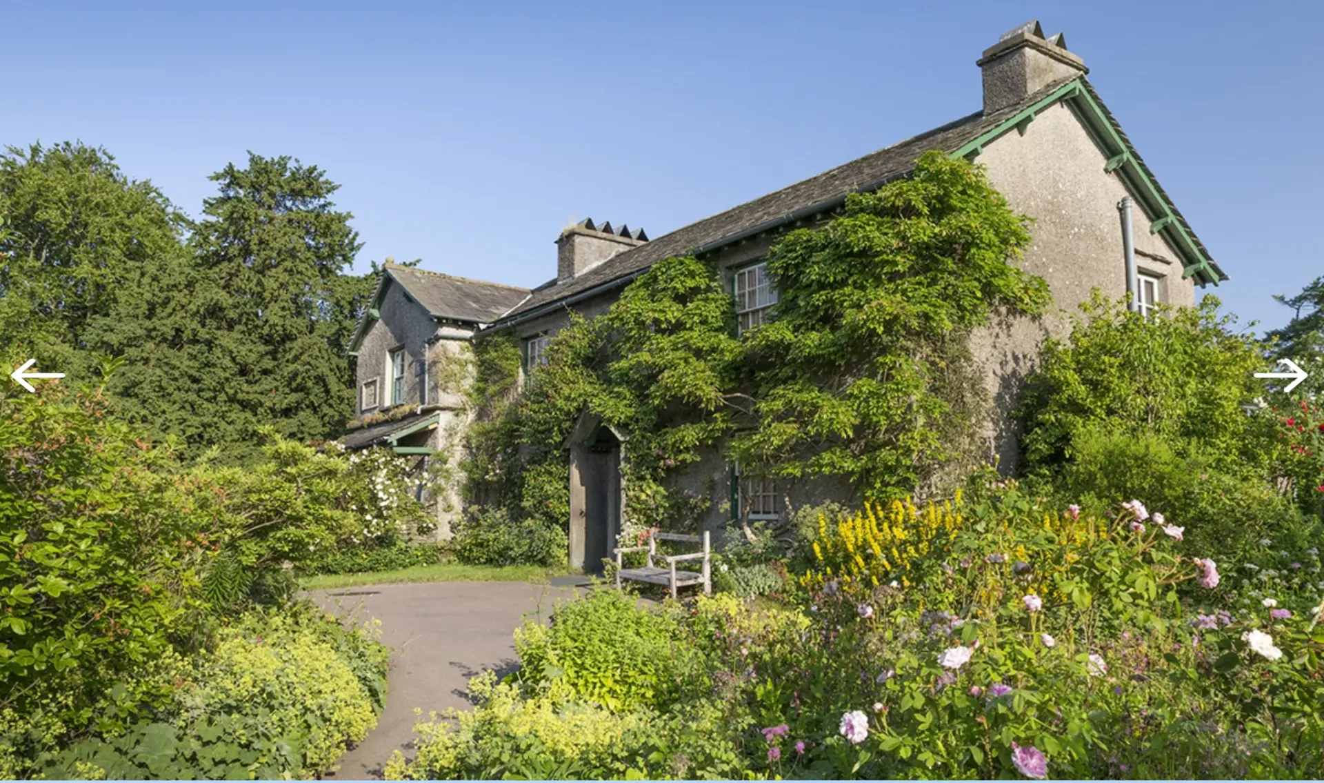 Hill Top Farm, Beatrix Potter's stone cottage covered in climbing plants with a flower-filled garden
